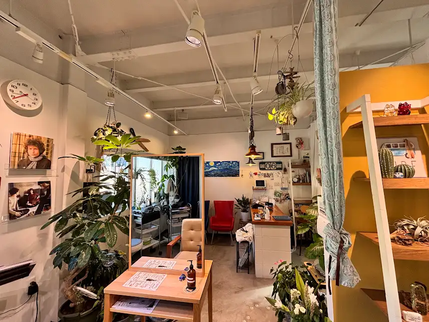 136ism の受付。観葉植物とレザーソファのある待合スペース